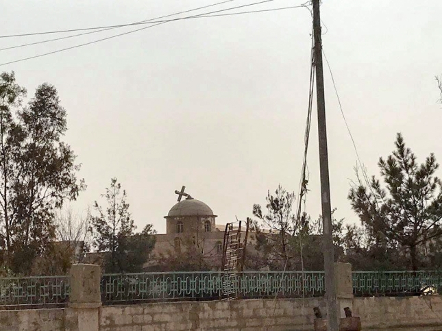 Cross pulled down on the top of a church in Qaraqosh.